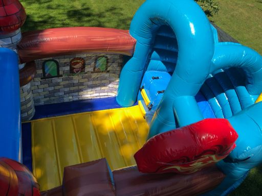 Hüpfburg Drachenland Innenansicht Buntes, aufblasbares Spielschloss mit Rutschen und interaktiven Elementen.